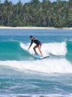 Beginner surfer, surfing the beach break with a soft top